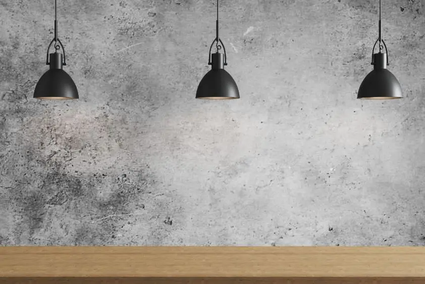 Three black pendant lights installed over a timber kitchen bench in Brighton