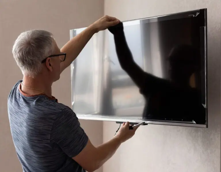 Technician levelling a wall-mounted TV in Sandringham