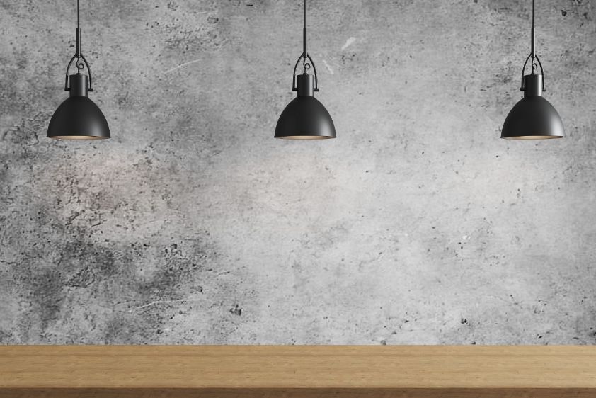 Three black pendant lights installed over a timber kitchen bench in Brighton