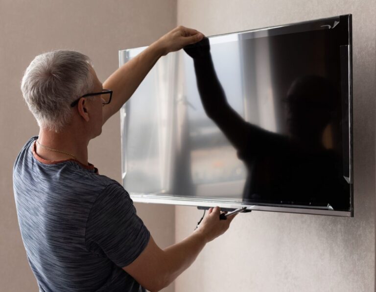 Technician levelling a wall-mounted TV in Sandringham